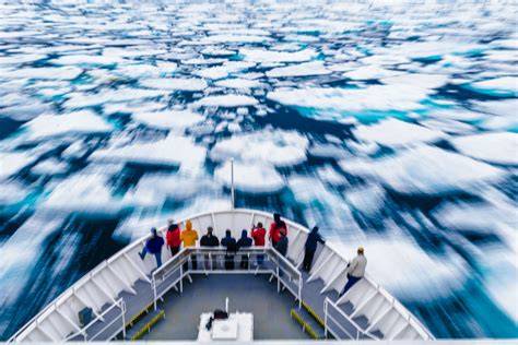 Cruise ship navigating through icy waters with passengers observing the surroundings