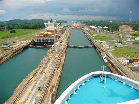 A cruise ship navigating through the Panama Canal, showcasing the intricate lock system and lush surrounding landscape.