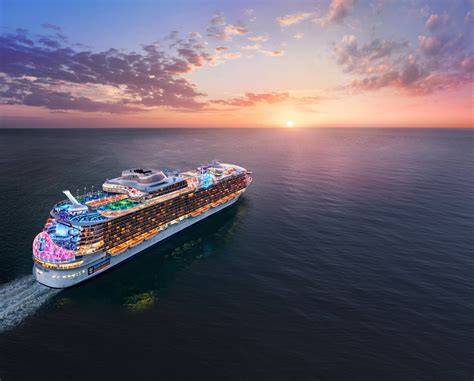 Cruise ship sailing into the sunset with colorful lights illuminating the decks