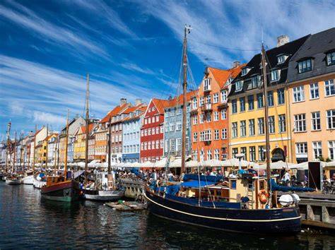 Colorful buildings and boats along the waterfront in Nyhavn, Copenhagen, Denmark.