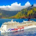 A luxury cruise ship sailing near the stunning cliffs and lush landscapes of the Na Pali Coast in Hawaii.