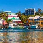 Colorful houses and boats along a scenic waterfront, representing a tropical cruise destination.