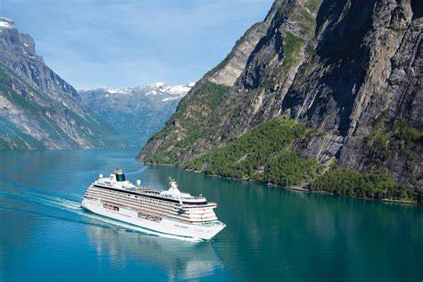 Luxury cruise ship sailing through the scenic fjords with towering cliffs and deep blue waters, perfect for adventure and group travel.