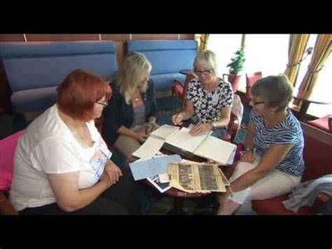 Group of women looking at photo albums together on a cruise ship.