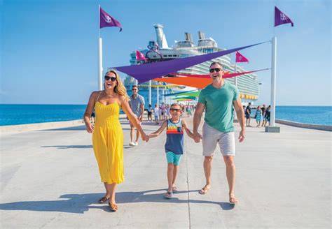 Family walking on the pier with a cruise ship docked in the background during a tropical getaway in the Bahamas.