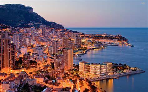 Nighttime view of Monaco's city lights and coastline