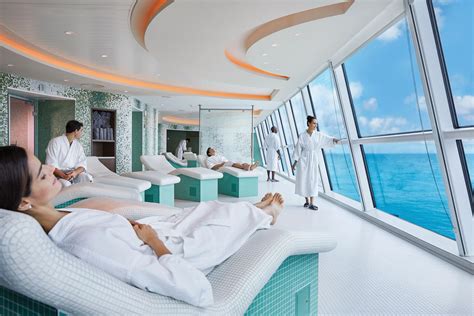 Passengers relaxing in a luxurious spa with panoramic ocean views on a cruise ship, enjoying the serene ambiance and top-notch amenities.