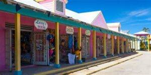 Colorful market shops in Nassau, Bahamas, featuring vibrant pink and yellow buildings.