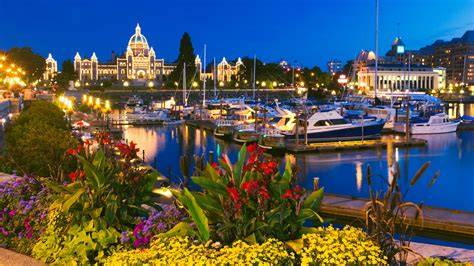 Scenic evening view of Victoria's Inner Harbour with illuminated buildings and boats docked