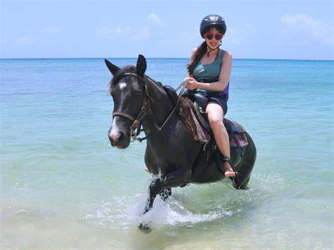 Woman enjoying a unique horseback riding excursion in the turquoise waters of the Caribbean, perfect for adventure cruises and exotic destination activities.