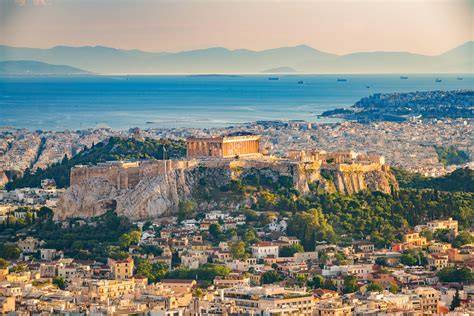 Aerial view of the Acropolis of Athens with the Parthenon, cityscape, and the Aegean Sea in the background