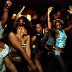 Group of Africans in America dancing energetically at a night event on a cruise ship