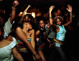 Group of Africans in America dancing energetically at a night event on a cruise ship