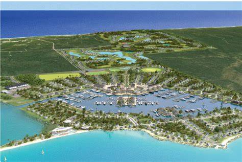 Aerial view of a resort and marina with lush greenery and turquoise waters in the Bahamas.