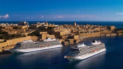 Luxury cruise ships docked at a scenic Mediterranean port, showcasing a picturesque city backdrop with historic architecture.