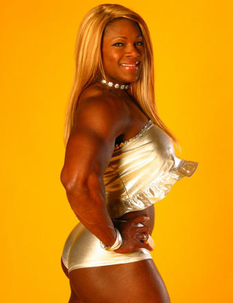 Woman wearing a shiny gold outfit, smiling confidently at the camera against a yellow background