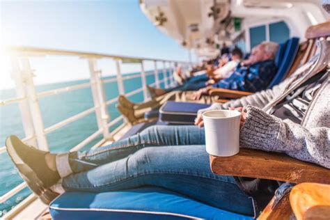 People relaxing on lounge chairs on the deck of a cruise ship, enjoying the ocean view