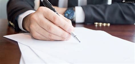 Business person signing documents with a pen