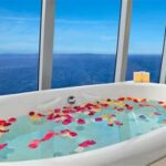 Luxurious bathtub with rose petals and ocean view on a luxury cruise ship.