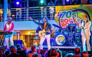 70s-themed rock and roll band performing live on a cruise ship stage