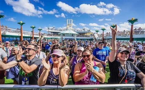 Crowd enjoying an event on a cruise ship deck under a bright blue sky