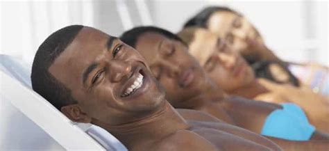 Group of people relaxing on lounge chairs onboard a cruise ship, with one person smiling at the camera