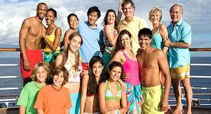 Large group of happy people on a cruise ship deck enjoying a sunny day during a group travel vacation.