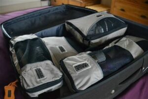 Suitcase packed with gray packing cubes for organized travel