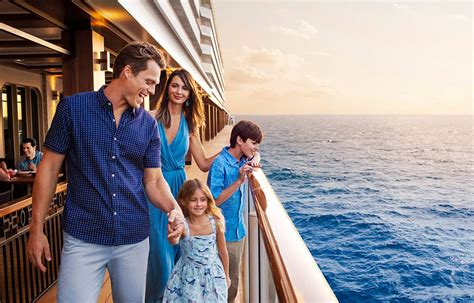 Family enjoying a walk on the deck of a cruise ship with the ocean in the background.