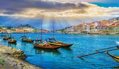 Traditional boats on a vibrant river against a backdrop of colorful buildings during a European river cruise.