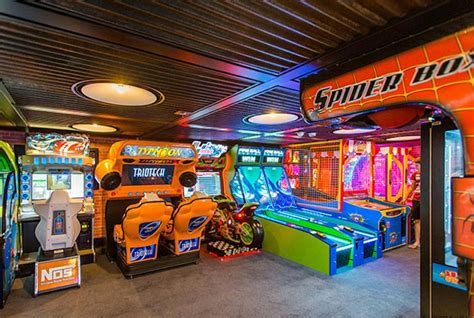 Brightly lit arcade room with various game machines onboard a cruise ship