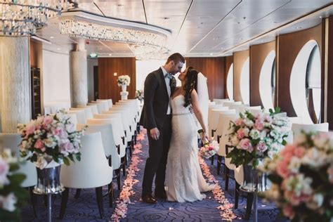 Bride and groom share a romantic moment in a beautifully decorated cruise ship wedding venue.