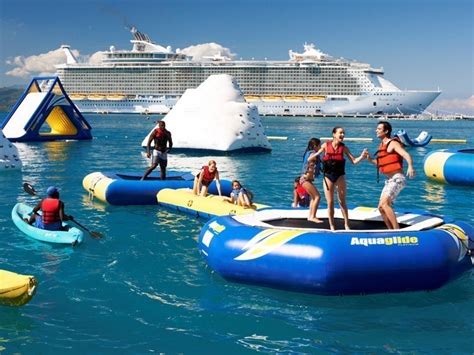 People enjoying water sports and activities with a large cruise ship in the background.