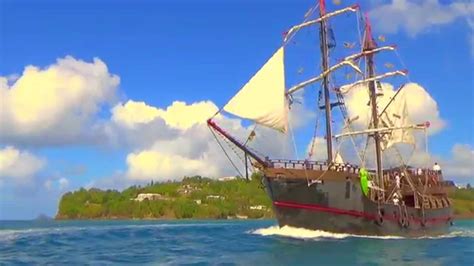 A majestic tall ship sailing near a tropical island during a themed cruise adventure.