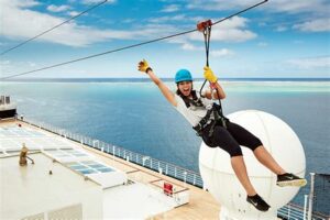 Woman ziplining on a cruise ship with a scenic ocean view in the background