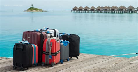 Luggage on a dock with overwater bungalows in the background