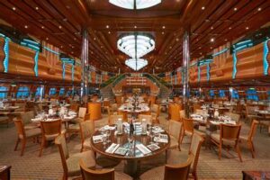 Spacious main dining room on a luxury cruise ship with elegant décor and multiple dining tables